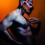 L'artiste Albinohector torse nu qui porte un masque de sa fabrication