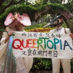L'artiste performeur non-binaire Holok Chen (à gauche) et un mannequin brandissent une banderole promouvant l'égalité LGBTQ devant un registre des mariages à Hong Kong.